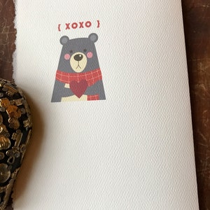 May include: A white card with a gray bear wearing a red and black scarf holding a red heart. The text "{XOXO}" is above the bear and the text "www.etsy.com/shop/S19design" is at the bottom of the card.