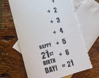 May include: A white card with black text that reads "1 + 2 + 3 + 4 + 5 + 6 = 21" and "Happy 21st Birthday!"