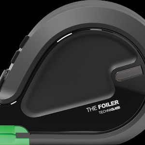 May include: A black and gray device with the text "THE FOILER TECHNIGLASS" on the front. The device has a curved design with a green accent on the bottom. It features buttons on the side and a sleek, modern aesthetic.