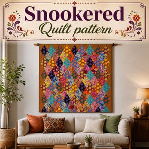 May include: A colorful quilt pattern with the text "Snookered Quilt pattern" displayed above. The quilt features a diamond pattern with various colors and patterns, including polka dots and floral designs. The quilt is hanging above a sofa.