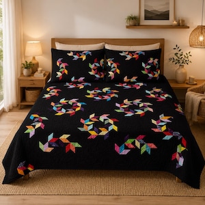 May include: A black quilt and two matching pillow shams featuring a repeating pattern of colorful, multi-hued geometric shapes arranged in circular and angular motifs. The bedding set displays a vibrant array of red, yellow, green, blue, and purple.