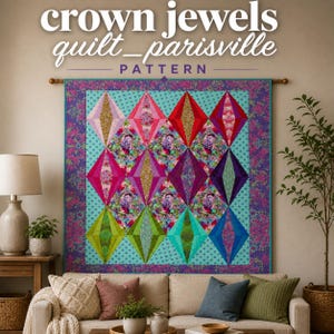 May include: A colorful quilt with a diamond pattern, displayed on a wall above a sofa. The quilt features various shades of pink, red, purple, green, and blue diamonds, with floral accents. The text "crown jewels quilt_parisville PATTERN" is at the top.