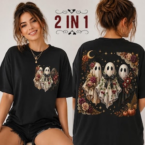 May include: A black t-shirt featuring a graphic of three ghosts adorned with flowers, berries, and a bow. The design is printed as a small chest logo and a large back print. The text 2 IN 1 is displayed in red above the shirt graphics.