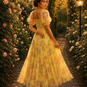 May include: A yellow midi dress featuring a square neckline, short puff sleeves, and a smocked bodice. The skirt is tiered and made of a sheer, layered fabric with a floral print in shades of pink and green. The dress is paired with beige sandals.