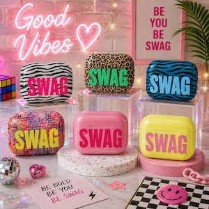 May include: Six rectangular earbud cases featuring various patterns and colors, each printed with the word SWAG. Designs include zebra print, leopard print, blue tiger stripes, multicolored dots, solid pink, and solid yellow with bold lettering.