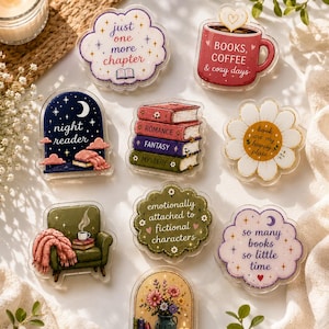 May include: A collection of nine acrylic pins featuring book-themed illustrations and text, including phrases like just one more chapter, books, coffee & cozy days, night reader, book are my happy place, and emotionally attached to fictional characters.