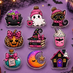 May include: A set of nine acrylic charms featuring Halloween-themed illustrations including a black cauldron with green bubbles, a ghost in a pink leopard print hat holding a mug, a black cat with glasses, a pumpkin, a stack of books, a drink, a potion bottle labeled Good Vibes, a crescent moon, and a house.