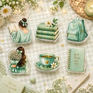 Op de afbeelding: Een set van zes decoratieve acrylstukken met illustraties in saliegroene tinten. De ontwerpen bevatten een lezend persoon, een stapel van drie boeken, een rugzak, een persoon met bloemen, een theekopje en een notitieboek met de tekst Good things take time.