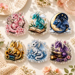 May include: A set of six acrylic charms featuring illustrated dragons. One is pink with cherry blossoms, one is teal on an open book, one is blue on a crescent moon, one is yellow with sunflowers, one is white with crystals, and one is purple with a lantern.