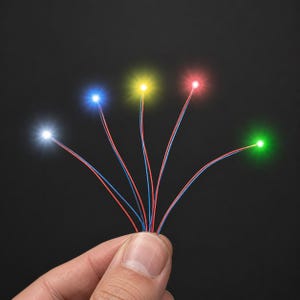 Peut inclure: Cinq fils électriques fins, chacun se terminant par une petite lumière LED brillante. Les lumières émettent des couleurs blanche, bleue, jaune, rouge et verte. Les fils sont regroupés à la base, chaque brin s'étendant vers l'extérieur.