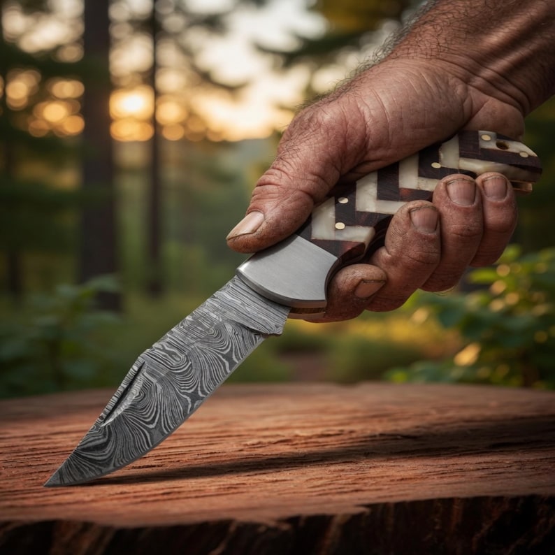 Folding pocket knife with polished steel blade and colorful inlay handle displayed on dark wood.
