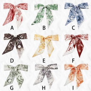 May include: Nine silk bow scarves in various colors, each featuring a unique design and a letter. Colors include red, green, blue, brown, yellow, and orange. The scarves have a decorative pattern.