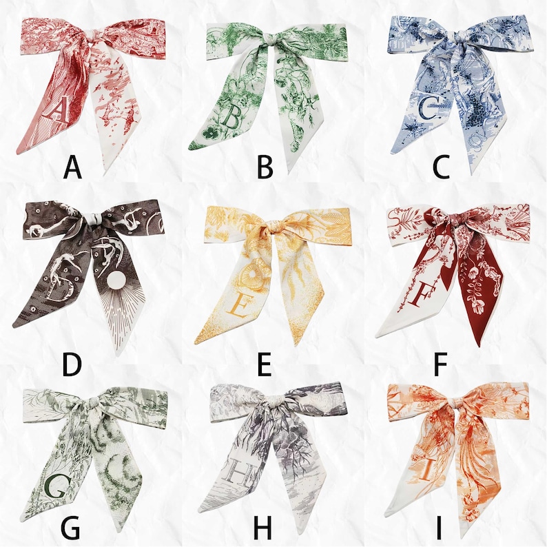 May include: Nine silk bow scarves in various colors, each featuring a unique design and a letter. Colors include red, green, blue, brown, yellow, and orange. The scarves have a decorative pattern.