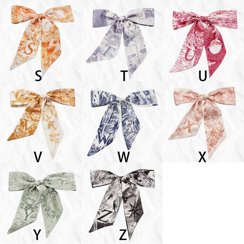 May include: Collection of silk scarves in various colors, each tied in a bow. The scarves feature unique patterns and the letters S, T, U, V, W, X, Y, and Z. Colors include orange, lavender, pink, brown, navy, peach, sage green, and black and white.
