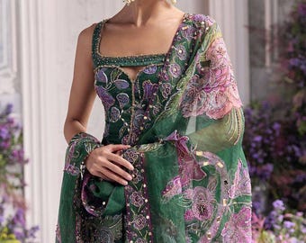 May include: A sleeveless emerald green dress featuring a square neckline and intricate embroidery with purple and pink floral patterns. The garment includes a matching sheer green dupatta draped over the shoulder, adorned with sequin accents and floral motifs.