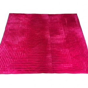 Puede incluir: Un edred&oacute;n grande y rectangular de color rosa intenso con un patr&oacute;n geom&eacute;trico. El edred&oacute;n tiene una superficie acolchada y texturizada con l&iacute;neas rectas que crean un dise&ntilde;o visual. Los bordes est&aacute;n cuidadosamente acabados y el edred&oacute;n est&aacute; sobre un fondo blanco.