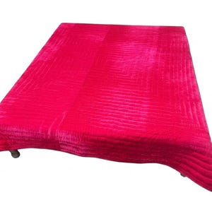 Puede incluir: Un edred&oacute;n fucsia vibrante con un patr&oacute;n acolchado texturizado. El edred&oacute;n rectangular est&aacute; drapeado sobre una superficie, mostrando su rico color y dise&ntilde;o. Los bordes del edred&oacute;n son ligeramente curvos.