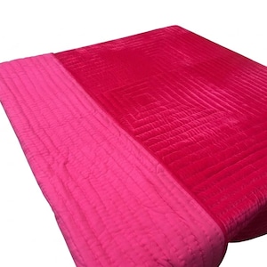Puede incluir: Una manta acolchada de dos tonos en tonos rosa y rojo. La manta presenta un patr&oacute;n cosido con una secci&oacute;n rosa m&aacute;s clara a la izquierda y una secci&oacute;n roja m&aacute;s oscura a la derecha. La textura parece suave y afelpada.