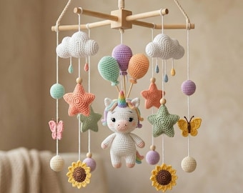 Pode incluir: Móvel de bebê feito à mão em crochê, com um unicórnio branco com chifre arco-íris, rodeado por estrelas, nuvens, borboletas, balões e girassóis coloridos. Suspenso em uma moldura de madeira.