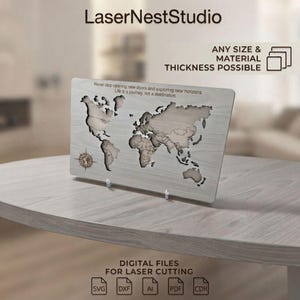 Pode incluir: Uma placa retangular de madeira clara com um mapa-múndi cortado a laser e uma rosa dos ventos. O texto diz: LaserNestStudio, ANY SIZE & MATERIAL THICKNESS POSSIBLE, Never stop opening new doors and exploring new horizons. Life is a journey, not a destination, e DIGITAL FILES FOR LASER CUTTING.