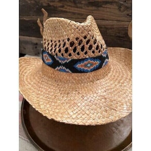 May include: A straw cowboy hat with a beaded band. The band is black with blue, orange, and white beads. The hat is light brown and has a woven texture.