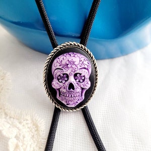 Collar con colgante de corbata de bolo estilo suroeste con punta plateada y calavera de azúcar morada
