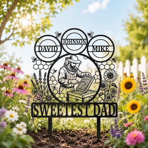 May include: Black metal garden stake featuring a beekeeper tending a hive, surrounded by bees, flowers, and the text "Sweetest Dad." Includes three circles with names: David, Johnson, and Mike. Perfect for a garden.