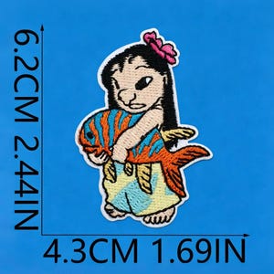 May include: An embroidered patch featuring a cartoon character with black hair and a pink flower, holding a large orange fish with blue stripes. The patch measures 6.2 cm by 4.3 cm, or 2.44 inches by 1.69 inches, as indicated by the visible measurement text.