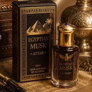 May include: An Egyptian Musk Attar perfume bottle and box. The black box features gold hieroglyphs, pyramids, and palm trees. The perfume bottle is clear with gold accents and a blue gem on the cap. The text on the bottle and box reads "Egyptian Musk Attar".