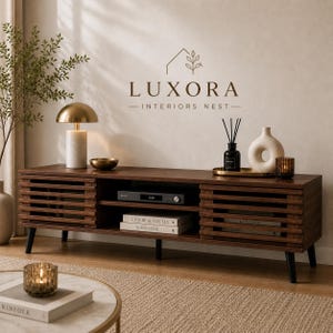 May include: A dark brown wooden media console with slatted doors and black legs. A gold-toned lamp, a small bowl, and decorative items sit on top. The console has a shelf for media components and books. The brand name "LUXORA - INTERIORS NEST" is visible.