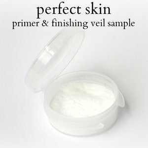 Puede incluir: Un pequeño recipiente de plástico transparente con polvo blanco en su interior. El recipiente está etiquetado como "perfect skin primer & finishing veil sample".