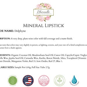May include: A product description for a mineral lipstick in the shade Delphyne. The text describes a deep plum wine color with full coverage and a matte finish. The image includes the brand's logo and ingredient information.