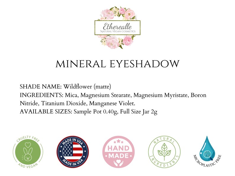 May include: A white label with the text "Etherealle Natural Vegan Cosmetics" and "Mineral Eyeshadow" in black. The label also includes the shade name "Wildflower (matte)", ingredients, and available sizes: Sample Pot 0.40g, Full Size Jar 2g. The label is surrounded by five circular icons: cruelty-free, made in USA, hand-made, natural ingredients, and microplastic free.