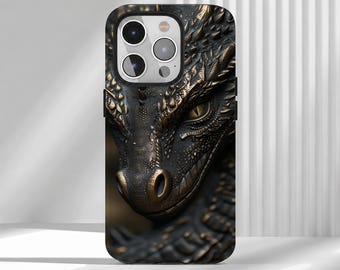 May include: A smartphone case featuring a detailed, dark bronze-colored dragon head design with textured scales and a sharp, piercing eye. The case has a cutout for a triple-lens camera system on the upper left side, showcasing a metallic finish.