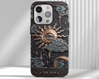 May include: A black phone case featuring a raised, embossed design of a sun with a central eye, surrounded by stylized blue clouds and gold stars. The bottom of the case displays the text THE SUN in a rectangular frame with Roman numeral XIX.