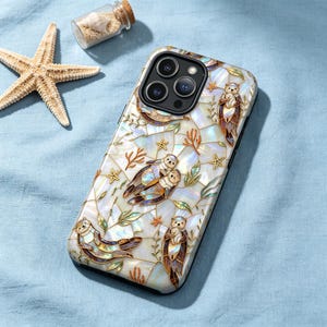 May include: A smartphone case with an otter design. The case has a white, iridescent background with inlaid otter figures, starfish, and seaweed. The case is designed for a smartphone with multiple camera lenses.