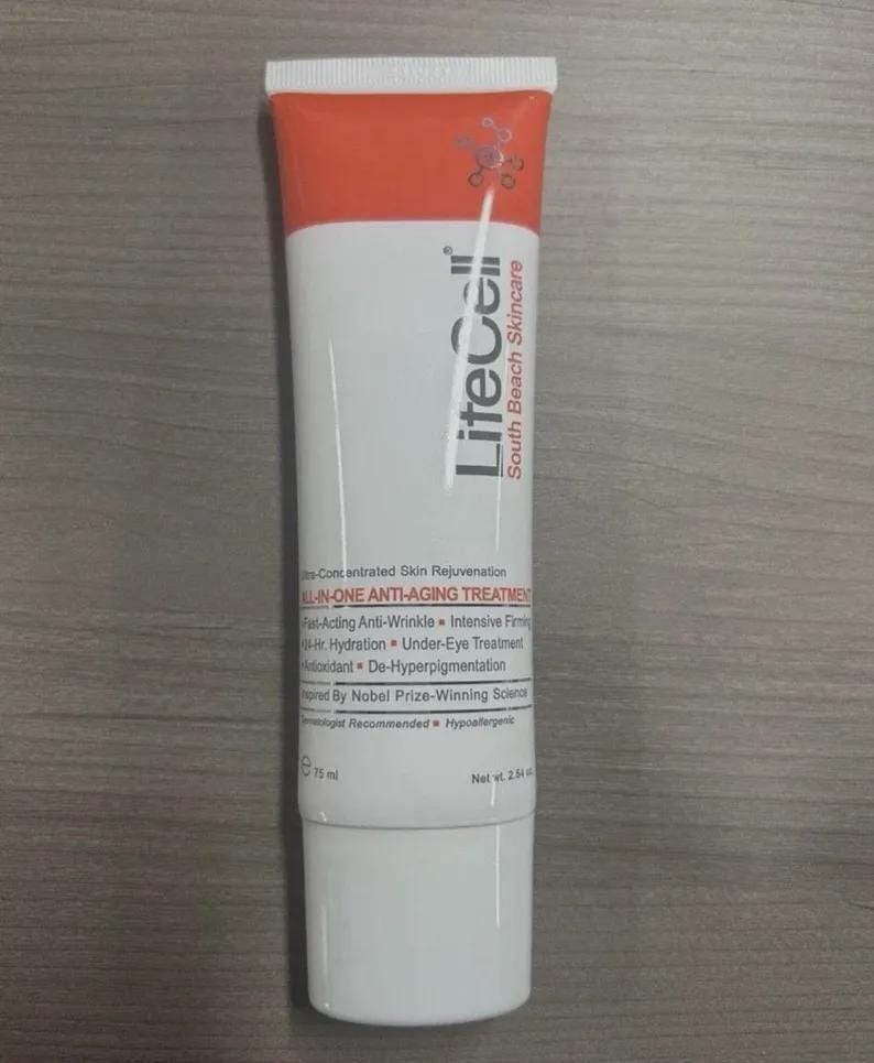 May include: A white and orange tube of LiteCell South Beach Skincare anti-aging treatment. The tube features the text "ALL-IN-ONE ANTI-AGING TREATMENT" and lists benefits such as anti-wrinkle and hydration. The net weight is 2.54 oz.
