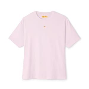 Puede incluir: Una camiseta rosa claro de manga corta. La palabra "RHIMI" está impresa en amarillo en el cuello. Un pequeño círculo amarillo bordado está centrado en el pecho.