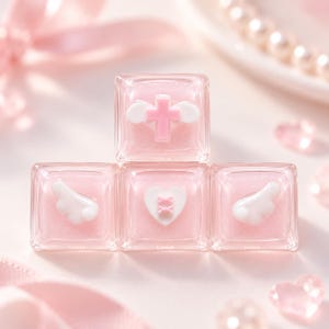 May include: Four square mechanical keyboard keycaps in a translucent light pink finish with glitter. The top keycap features a pink cross with white wings. The bottom row displays white wings, a white heart with pink crosses, and white wings.