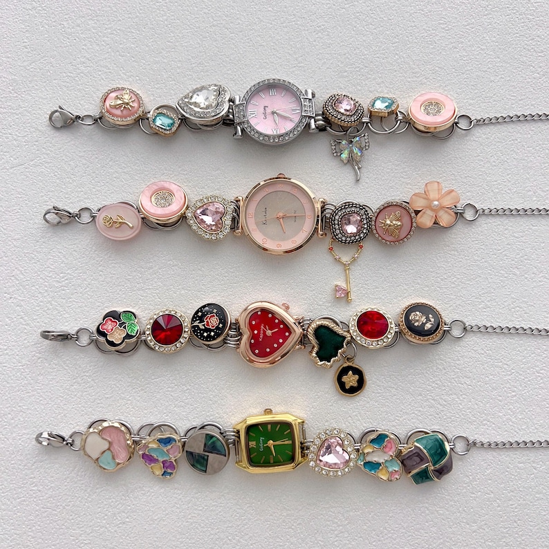 May include: Four decorative watch bracelets with various charms and watch faces. The bracelets feature pink, green, and red watch faces, along with heart, flower, and gem-shaped charms. The bracelets are connected by a silver chain.