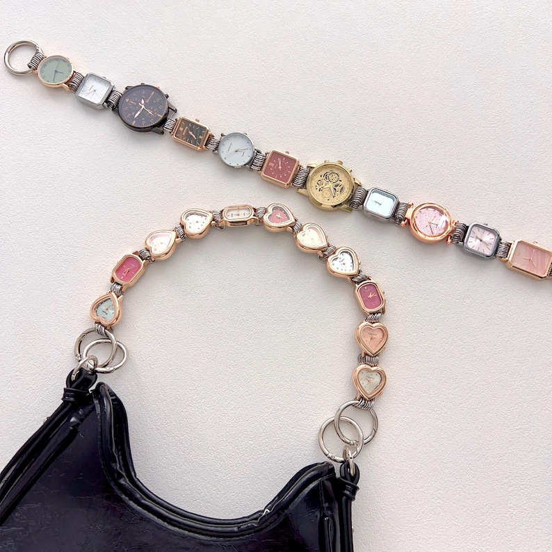 May include: A black patent leather handbag with a unique handle made of heart-shaped watch faces in various colors. A second watch-face bracelet with different shaped watch faces is also visible. The watches have silver and gold-tone metal.