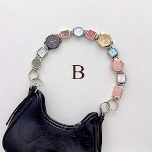 May include: Black handbag with a unique strap made of various small, colorful watches. The watches are in different shapes and colors, connected by silver rings. The letter "B" is printed on the background.
