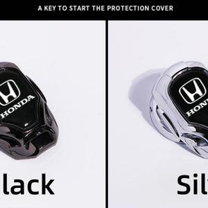 May include: Black and silver Honda key fob covers. Each cover has the Honda logo in white on a black background. The text "Black" and "Silver" are below each cover. The text "A KEY TO START THE PROTECTION COVER" is at the top.