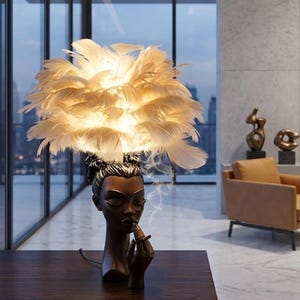 May include: A decorative table lamp featuring a woman's head with a feather lampshade. The lamp is brown with a woman's head smoking a cigarette. The lampshade is made of white feathers. The lamp is on a dark brown table.