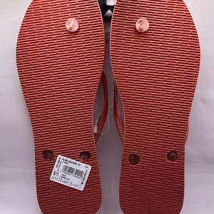 K&ouml;nnte beinhalten: Paar korallenfarbene Flip-Flops mit strukturierten Sohlen. Die Flip-Flops haben ein schlichtes Design mit einem Zehenriemen. Die Sohlen sind einfarbig korallenfarben und die Riemen sind in einem helleren Korallton gehalten. Die Flip-Flops sind neu und ungetragen.