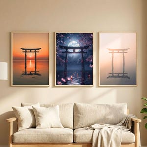 以下が含まれることがあります： 日本の鳥居の3つの額入りアートプリント。プリントは、夕日、月明かりの夜、霧のかかった夜明けなど、穏やかな環境にある門を描いています。アートワークは、白いクッションと織りのラグが付いたベージュのソファの上に展示されています。