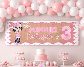 Puede incluir: Una pancarta de fiesta con fondo color canela y lunares rosas, una ilustración de Minnie Mouse y el texto Oh MINNIE! Kaliyah is 3. La pancarta está enmarcada por un borde festoneado blanco y rodeada por un arco de globos rosas y blancos.