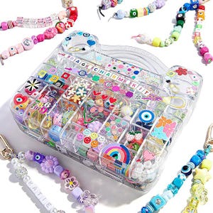 May include: A clear plastic organizer case labeled BAG CHARM KIT filled with assorted colorful beads in shapes like hearts, flowers, rainbows, and smiley faces, surrounded by several finished beaded bag charm strands with various charms.