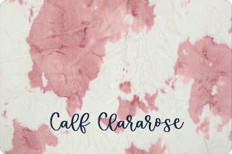 May include: A plush, textured blanket with a white background and large, irregular patches of dusty rose. The words "Calf Clararose" are written in a cursive font across the bottom.