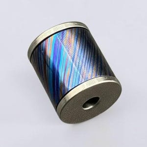 May include: A cylindrical object with a metallic finish. The body features a pattern of blue, purple, and silver diagonal lines. The top and bottom have a silver rim. The object has a hole in the center of one end.